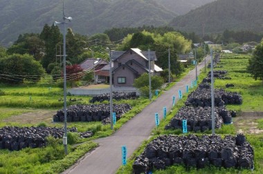 Piles of radiated soil lay along the side of a road in a deserted town near the destroyed Fukushima Daiichi nuclear power plant on June 22, 2015 (Keystone)