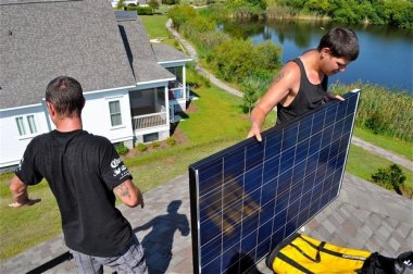 Workers from Sunstore Solar Energy Solution install solar panel. Photo by David Quick, Charleston Post Courier staff.