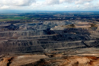 Open pit coal mine in green countryside.
