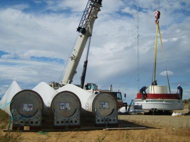 Alaska Environmental Power workers and contractors prepare to hoist the hub of a rotor and the three large blades to a hub. Photo: Tim Ellis/KUAC