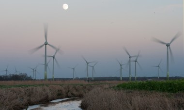 The full moon shines behind a wind park near Norden, Germany. Photograph: Ingo Wagner/dpa/Corbis
