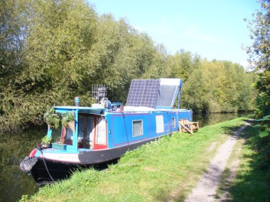 Solar Power on the Grand Union Canal. This narrowboat has been modernized and its two solar panels were collecting rays from a cloudless Hertfordshire sky. Photo by Colin Smith. CC BY-SA 2.0 Generic. Wikimedia Commons.
