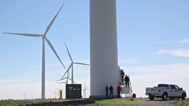 MidAmerican personnel examine a wind turbine